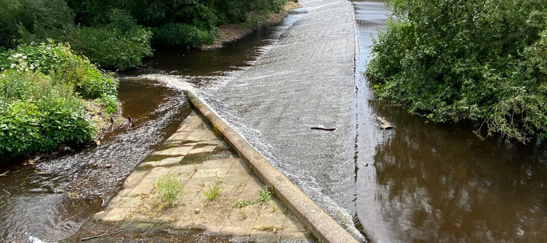 Baulk easement fish pass at Kelham Island Weir, showing a sloping beam creating a narrow water channel across the weir to help fish move upstream.