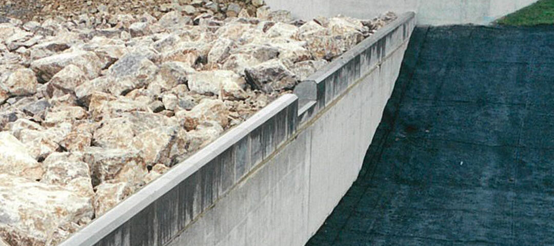 Headwall of the Orgreave rock ramp fish pass on the River Dearne during installation, with boulders forming a sloped channel beside a concrete weir.