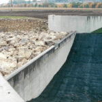 Headwall of the Orgreave rock ramp fish pass on the River Dearne during installation, with boulders forming a sloped channel beside a concrete weir.