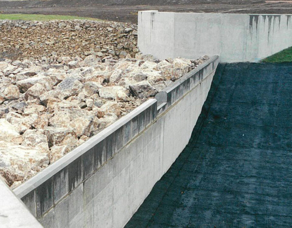Headwall of the Orgreave rock ramp fish pass on the River Dearne during installation, with boulders forming a sloped channel beside a concrete weir.